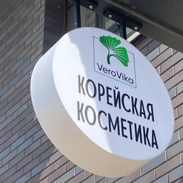 Круглая консольная вывеска магазина косметики на фасаде