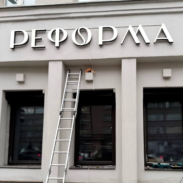 Монтаж объёмных букв на фасаде здания с лестницы