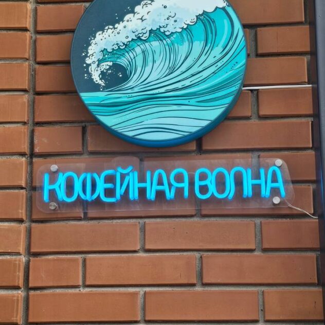 Неоновая надпись и круглый короб кофейни на стене