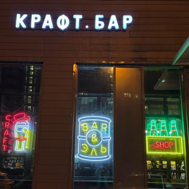 Неоновые вывески в витринах крафтового бара ночью