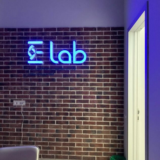 Неоновый логотип Lab на кирпичной стене офиса