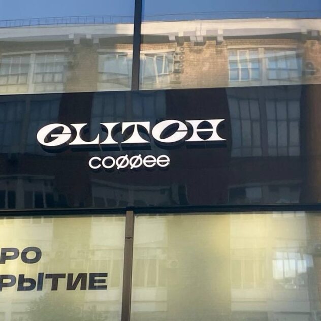 Плоские буквы кофейни на тёмной композитной подложке над витриной