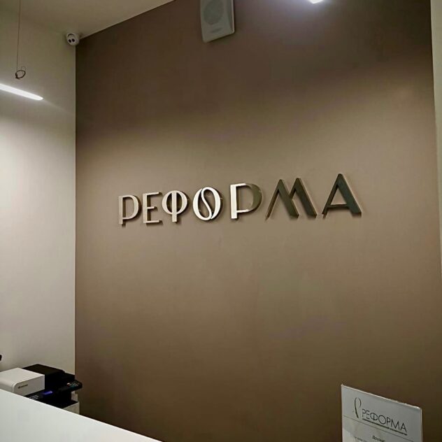 Зеркальные плоские буквы на стене над ресепшн салона