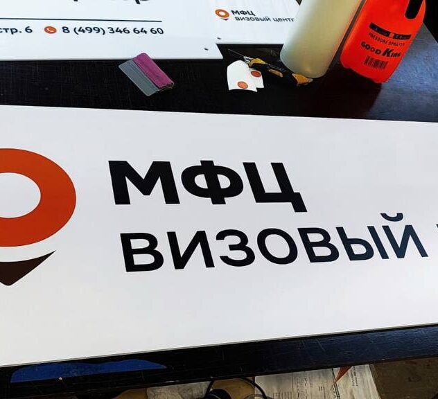 Плоская вывеска визового центра на столе в цехе