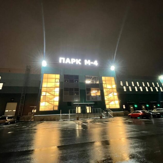 Крышная вывеска торгового комплекса ночью с парковки