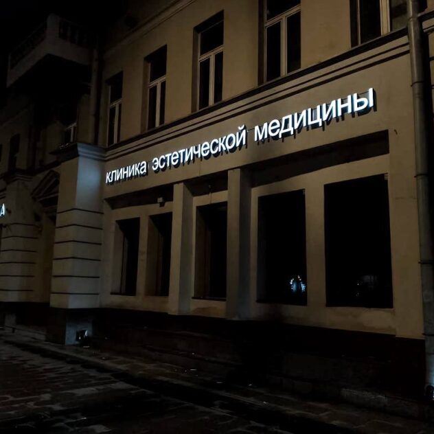 Ночной фасад со световыми буквами вдоль улицы