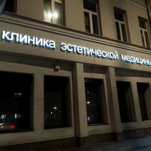 Световые буквы клиники на фасаде здания ночью