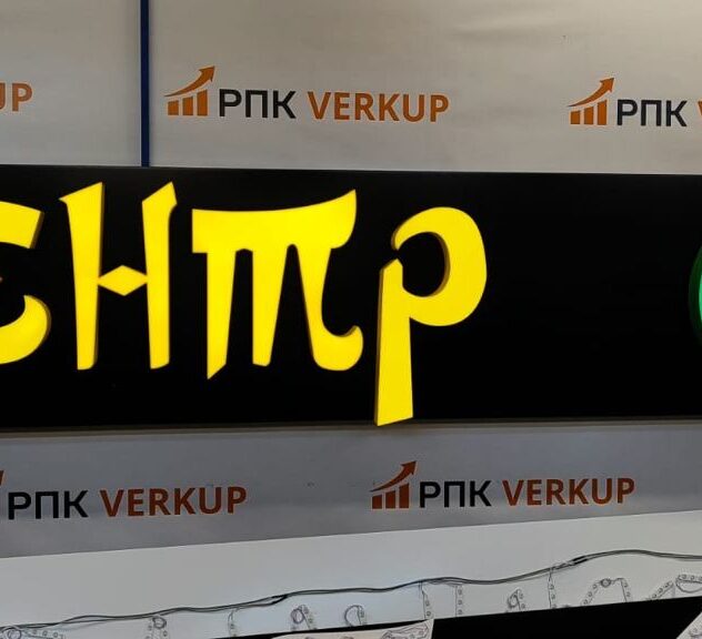 Вывеска магазина с жёлтыми световыми буквами на чёрной панели